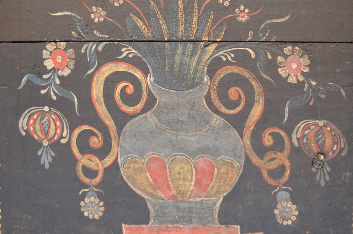 Rosemåla kiste med blomar, rankar, urner, prikkar og skrift. Påført skrift seier: Dortte Amunds Datter Mosagger Anno 1822.