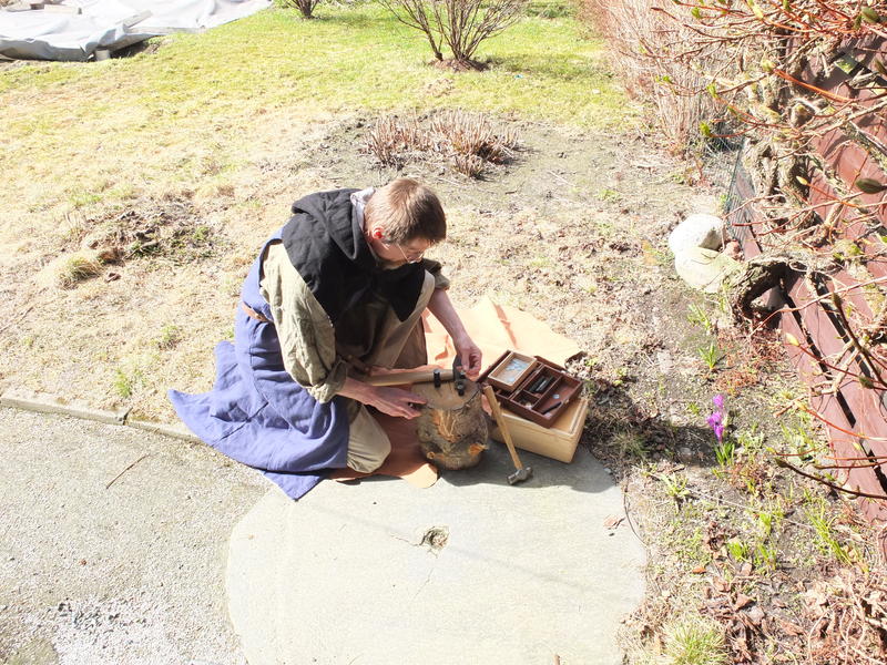 Mann i middelalderklær som slår mynt