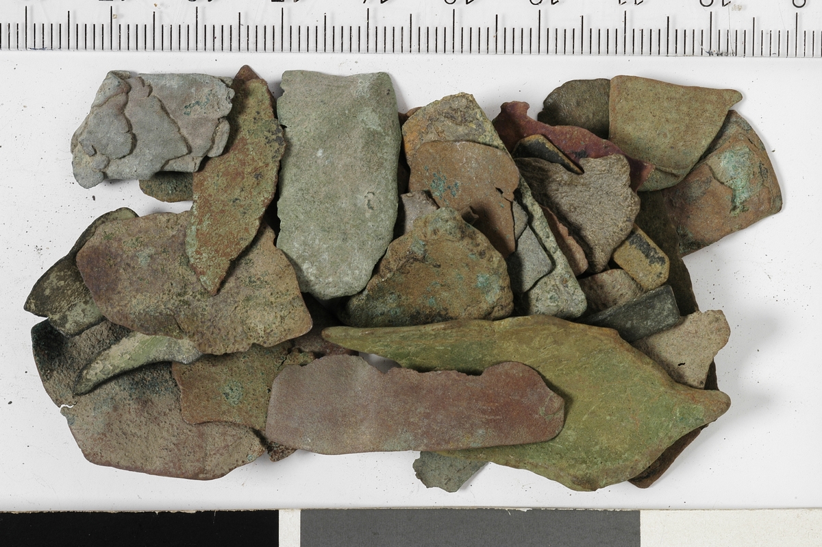 Diverse tynne avklipp av kobberplater. Dette er avfall fra verkstedenes metallhåndverk.