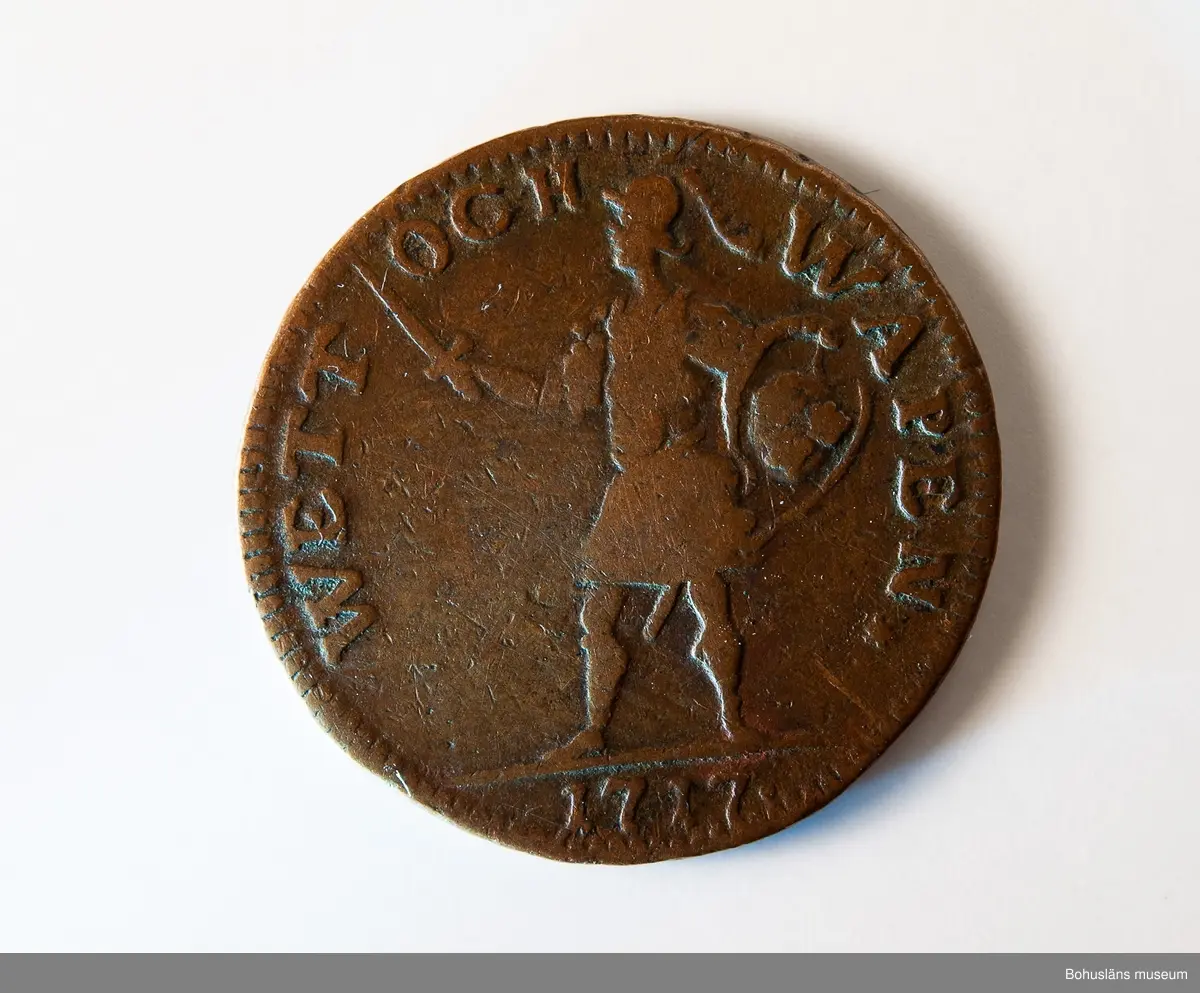 1 daler silvermynt 1717, "WETT OCH WAPEN", koppar, Stockholm.
Mynt präglat under Karl XII:s regeringstid.

Åtsidan: 
Frånsidan: I DALER S.M. på tre rader.
Myntets ytterrand refflad, vinkelrätt.

Material: koppar med tvångsvärde 1 daler silvermynt.

Karl XII 1682 - 1718, kung av Sverige 1697-1718.
Förvärvsdatum okänt.