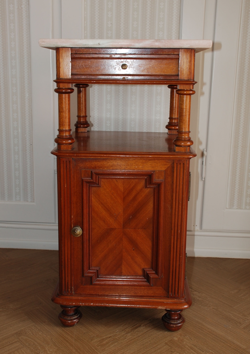 Mørk brunt nattbord med marmorplate på toppen. En skuff og skap. Åpen hylle over skapet.