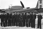 F6 Karlsborg 1953. GFSU-elever och lärare. Från vänster: Tage Nordkvist, Rolf Lindgren, Lars Johansson, Kjell Rörstrand, Kjell Persson, flygstyrkechefen Torsten Pedersen, lärare Signar Åström, Rolf Berg, Karl-Erik Crona, Ingemar Hoas, Lärarna Svante Bostrand och Carl-Ivar Norell. I bakgrunden flygplan A21 blå Helge. Albumet är en del av en donation från Karl-Axel Hansson, Karlsborg. Förteckning över hela donationen finns i albumet samt som Word-dokument.