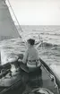 En ung kvinna i fören på en segelbåt.