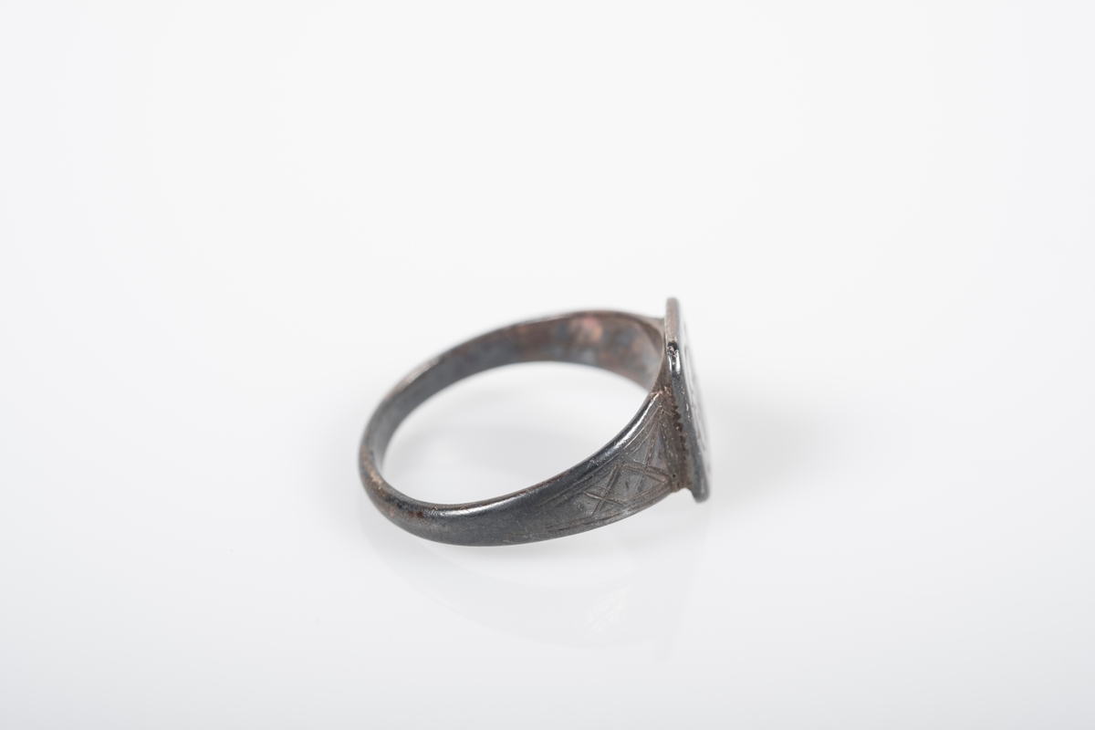 Rund ring i med et firkantet monogram hvor initialene D.O er inngravert. På innsiden står det Grini 1943.