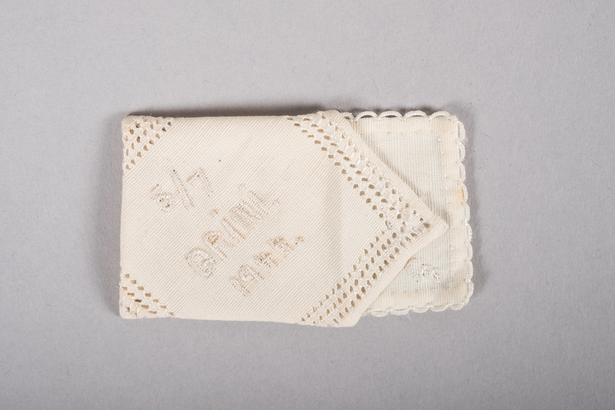 To små tøybiter sydd som et brev og en konvolutt.

"Konvolutten" er pyntet med hullbroderier og det står brodert:
"5/7
GRiNi.
1944"

"Brevet" har en heklet kant og et brodert "G".