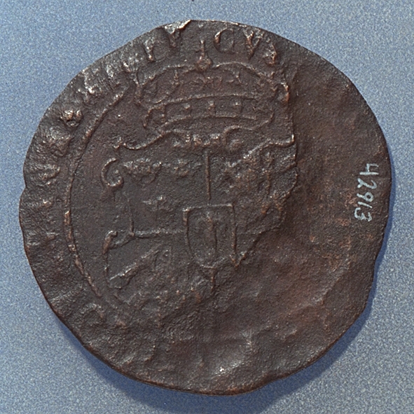 1 öre
Runt mynt.
Åtsidan: mitt på myntet det svenska riksvapnet, delvis synligt.
Omskriften, med Gustav Adolfs titlar på latin, är delvis synlig.
Frånsidan: två korsade pilar under en krona, svagt synliga.
Till vänster om pilarna siffran 1 svagt synlig. Omskriften på latin, med bland annat präglingsåret 1628, är till största delen oläslig.
Ocentrerad prägling.
Nuvarande skick: bägge sidor mycket slitna.

Text in English: Round coin. Denomination: 1 öre.
The obverse side has the Swedish coat-of-arms in the centre which is partly visible. The legend - in latin - has the titles of Gustav Adolf. The titles are partly visible.
The reverse side has two crossed arrows beneath a crown, faintly visible. On the left-hand side is the numeral 1. The legend, with the year of coinage, is in latin and partly legible. The date is 1628.
The coin stamp is off-centre.
Present condition: both sides are very worn.
Weight: 16,7 gram.