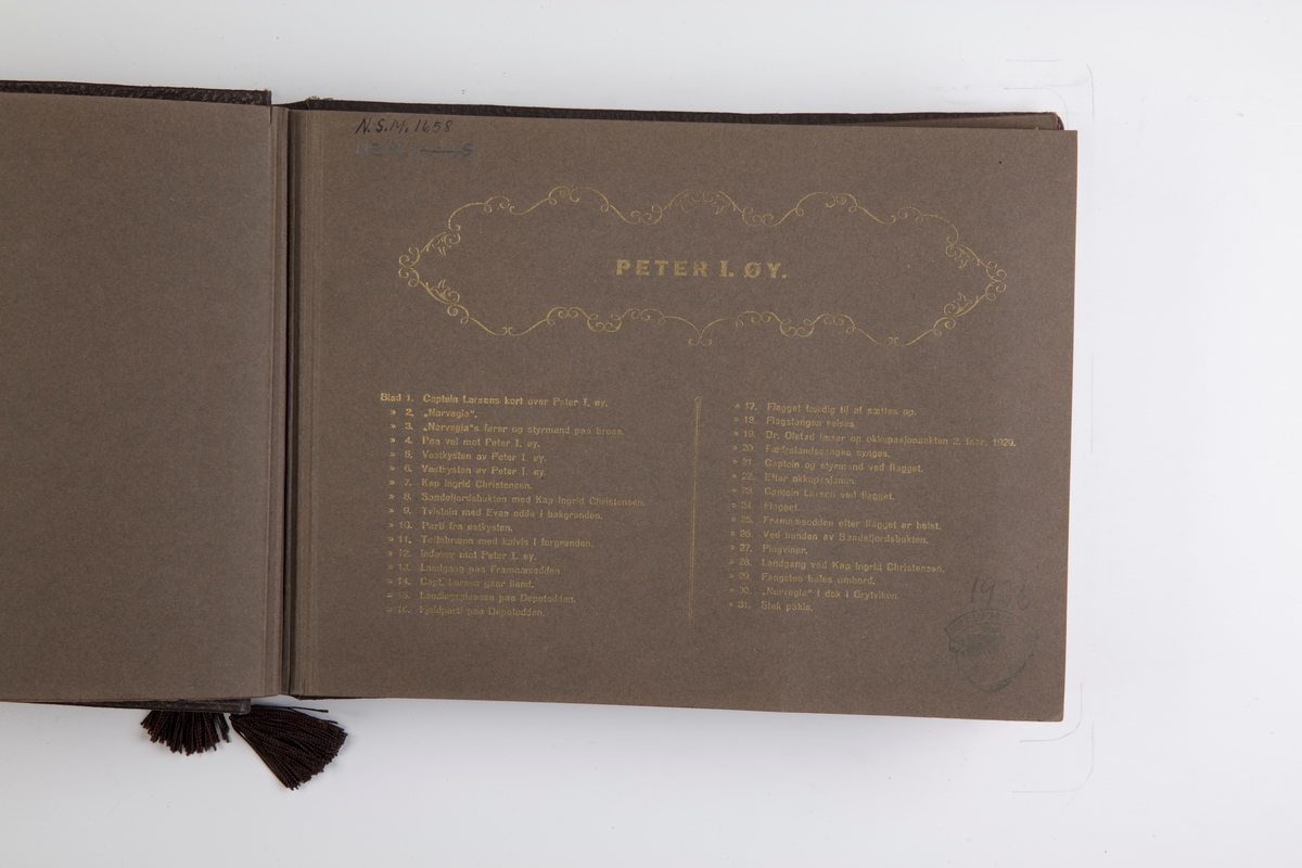 Fotoalbum med 30 fotografier og ett kart fra Norvegiaekspedisjonen til Peter I Øy 1927-1931.