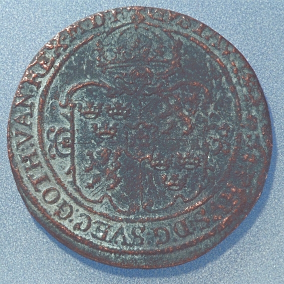 1 öre
Runt mynt.
Åtsidan: mitt på myntet det svenska riksvapnet, svagt synligt.
Omskriften med Gustav Adolfs regent titlar delvis synlig.
Ocentrerad prägling.
Frånsidan: en örn framifrån med utbredda vingar, svagt synlig. Under örnen siffran 1 och versalerna ÖR.
Omskriften på latin med bland annat det fyrsiffriga präglingsåret, 1627, är delvis läslig.
Ocentrerad prägling.
Nuvarande skick: bägge sidor slitna.
Vikt: 18,1 gram.

Text in English: Round coin. Denomination: one öre.
The obverse side has the Swedish coat-of-arms in the centre, faintly visible. The legend has the regent titles of Gustav Adolf. The titles are only partly legible.
The coin stamp is off-centre.
The reverse side shows an eagle en face with wings spread out, faintly legible. Beneath  the eagle is the numeral 1 and the initials ÖR, which appear in capital letters. The legend has a Latin inscription and the four digit date of coinage, 1627. The Latin inscription on the legend is faintly visible.
The coin stamp is off-centre.
Present condition: both sides are worn.
Weight: 18,1 gram.