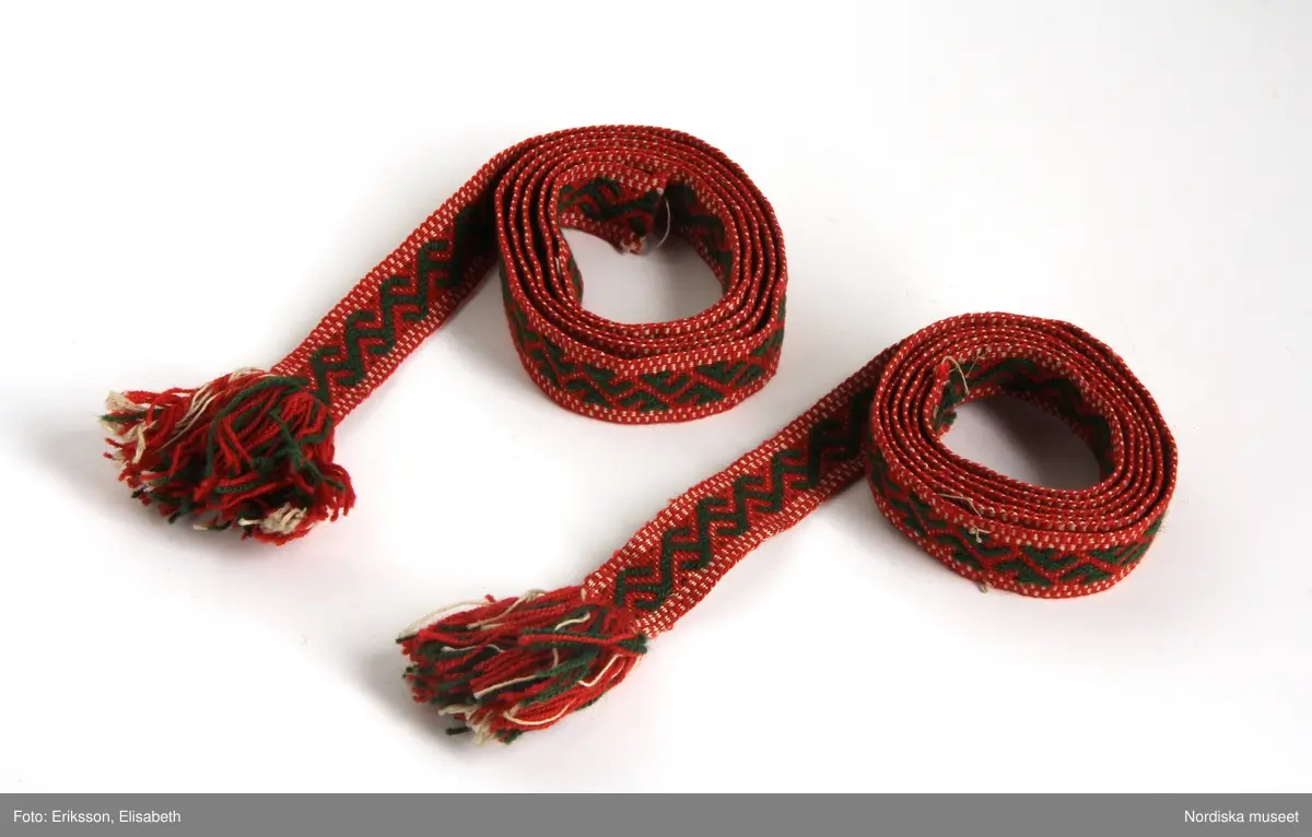 a. Livstyckskjol med liv av grön vadmal och randig halvyllekjol
b.Kvinnotröja, kort modell av svart kläde, med litet skört.
c. Halskläde av rödbottnad kattun
d. Halskläde av röd/gulrutig bomullslärft
e. Kjolväska  av svart kläde med applikationer av vadmal med tenntrådskonturer.
g: 1-4,  mjuk bindmössa av ljusblå sidenbrokad med vita spetsbandsmönster samt blommönster i rosa, mörkrött, vitt och grönt mm.

Dräktdelarna förefaller att vara från något olika tider, och sammansatta för att bli en hel dräkt vid insamlandet till museet. För att illustrera ett äldre dräktskick på orten. 
/Berit Eldvik 2012-02-14