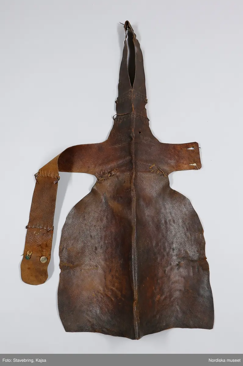 Huvudliggaren:
"Mandräkt från Boda sn Dalarna
A. Rock, längd 107 cm (m. kraglinning)
B. Skinnbyxor
C. Väst "livstycke"
D. Skor
E. Förskinn "skimpa"
F. Bröstlapp "halskrage"

A. Rock av svart vadmal, 2 fram- och 2 ryggstycken, helskurna. På insidan av framkanterna röda klädeslister, den högra med 6 hakar av mässing, på den vänstra 6 hyskor på utsidan. Isydd ärm med ärmsprund med hake och hyska och infodring av oblekt linnelärft. Kring halsen en 2,4 cm bred halslinning. Öppningar i sidsömmar.

Berit Eldvik 2004