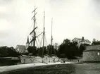 Skonare vid lastkajen. Gustavsbergs kyrka i bakgrunden, färdigställd 1907. Till höger i bakgrunden skymtar Värdshuset.