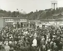 Exteriörbild. Scenunderhållning i samband med invigningen den 24 april 1964 av det nybyggda Domus, Gustavsbergs centrum.
Personer: Okända personer.