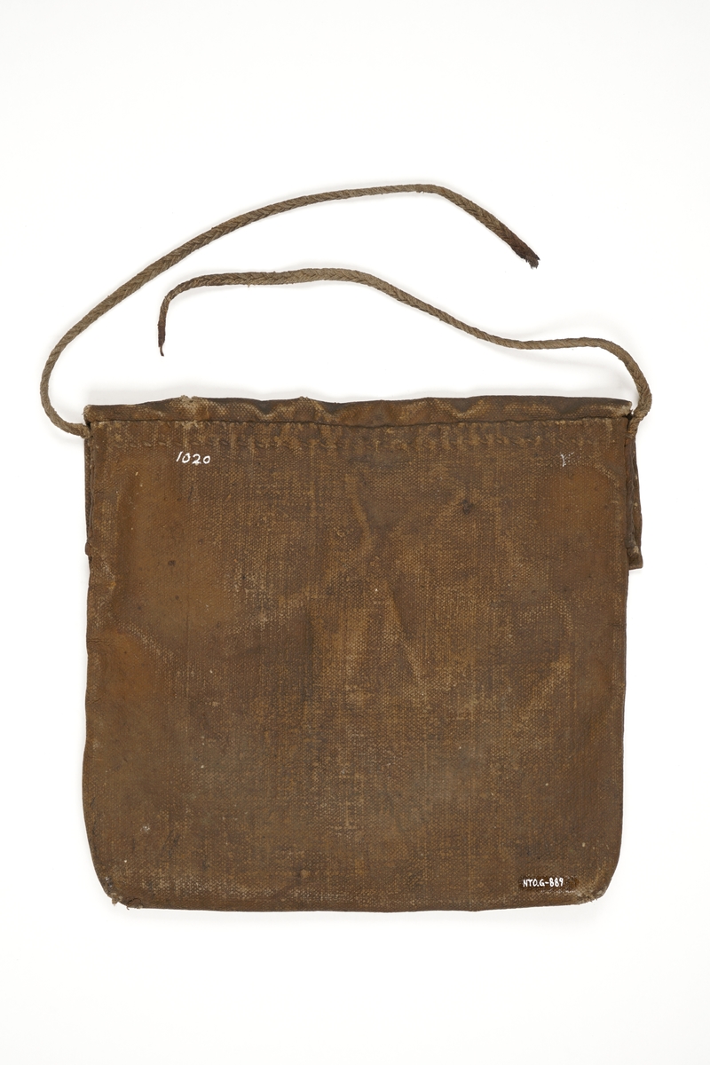 Veske av oljet seildukstekstil (i henhold til tidligere registrering), hvor lokket låses med rem av lær med knappehull og knapp av antatt tre festet på vesken.. En bærestropp av flettet tekstiltau er sydd fast i begge ender på veskens bakside. Tauet har røket.