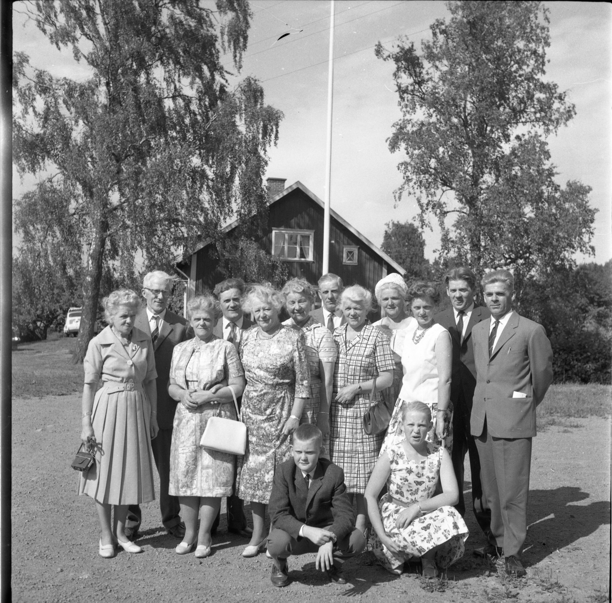 Skolträff i Reaby 1962. Kvinnor, män och barn uppställda på skolgården. Främre rad trea fr v: Ruth Pettersson och Anna-Lisa Lundin. Barnen heter Rune Gustavsson och hans syster Gun-Britt Gustavsson.