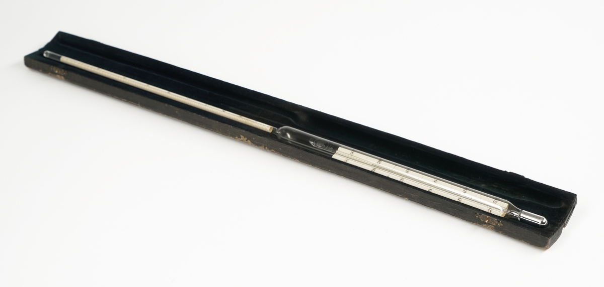 Termometer av glass  som ligger i et etui med lokk og to låser/hemper