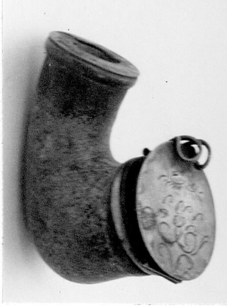 Piphuvud av masurbjörk med ring och fällock på gångjärn. Locket dekorerat med rankor och märkt med initialerna "SBS" (se märkning bild). Stämplar.