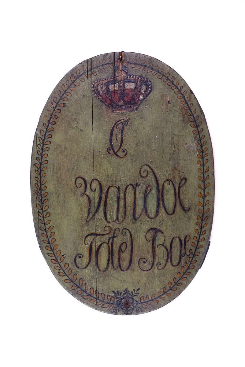 Bemalt trepanel med oval form. Panelet er satt sammen av to planker og med en liten "flis" på venstre side for å fullføre den ovale formen. To mindre, horisontale planker er spikret fast bak for å bidra til å holde plankene sammen. Panelet har grønn bemaling med bladbord i i gull- og sortmaling langs kanten. Dekorert med krone i gull, rødt, hvitt og sort over bokstavene "CJ". Resten av skriften lyder "Vardoe Told Boe"