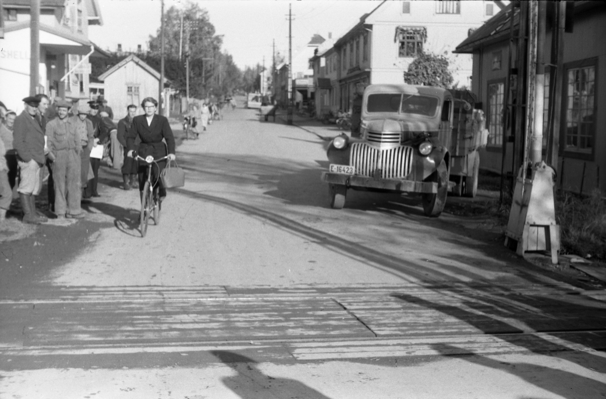Fire bilder ettter et biluhell ved jernbaneovergangen og Felleskjøpets lager på Lena, september 1952. Uvisst hva slags uhell, men en lastebil med tilhenger, lastet med mjølkespann er tydeligvis innblandet. Lastebilen med reg.nr. E-16423 er en Chevrolet årsmodell 1946 eller 1947.