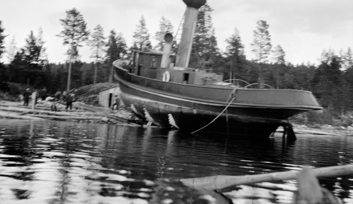 D/S Storsjø landsettes 7. mai 1915.  Fotografiet er tatt fra en robåt på Storsjøen.  Det viser båten med akterenden i innsjøen mens båten fortsatt støttes opp av bukker på slippen.  Fartøyet er bygd av jern, og platene i skroget er klilnket sammen.  På dekk ses ei lita kasse med dør, som antakelig er nedgangen til maskinrommet.  Foran denne ses ei høy skorsteinspipe med gnisthatt.  Foran denne igjen ses styrhuset.  På land, til venstre for båten står en del menn på slippen, som er en steinforet tømmerkonstruksjon.  Ved siden av slippen ses gavlen på ei bu som er delvis nedgravd i strandbakken.  Bakom dette vokser det barskog. 

Direksjonen i Glomma Fellesfløtingsforening vedtok å investere i en dampbåt som skulle trekke tømmer i bommer over denne sjøen i 1911.  Båten var ferdig og ble satt i drift allerede påfølgende sesong. 