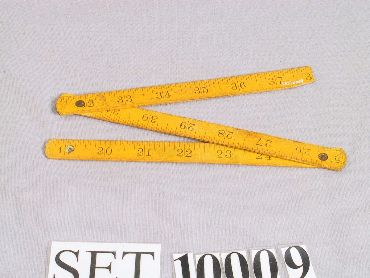 Samanbrettbar tommestokk med centimeter- og tommeinndeling.