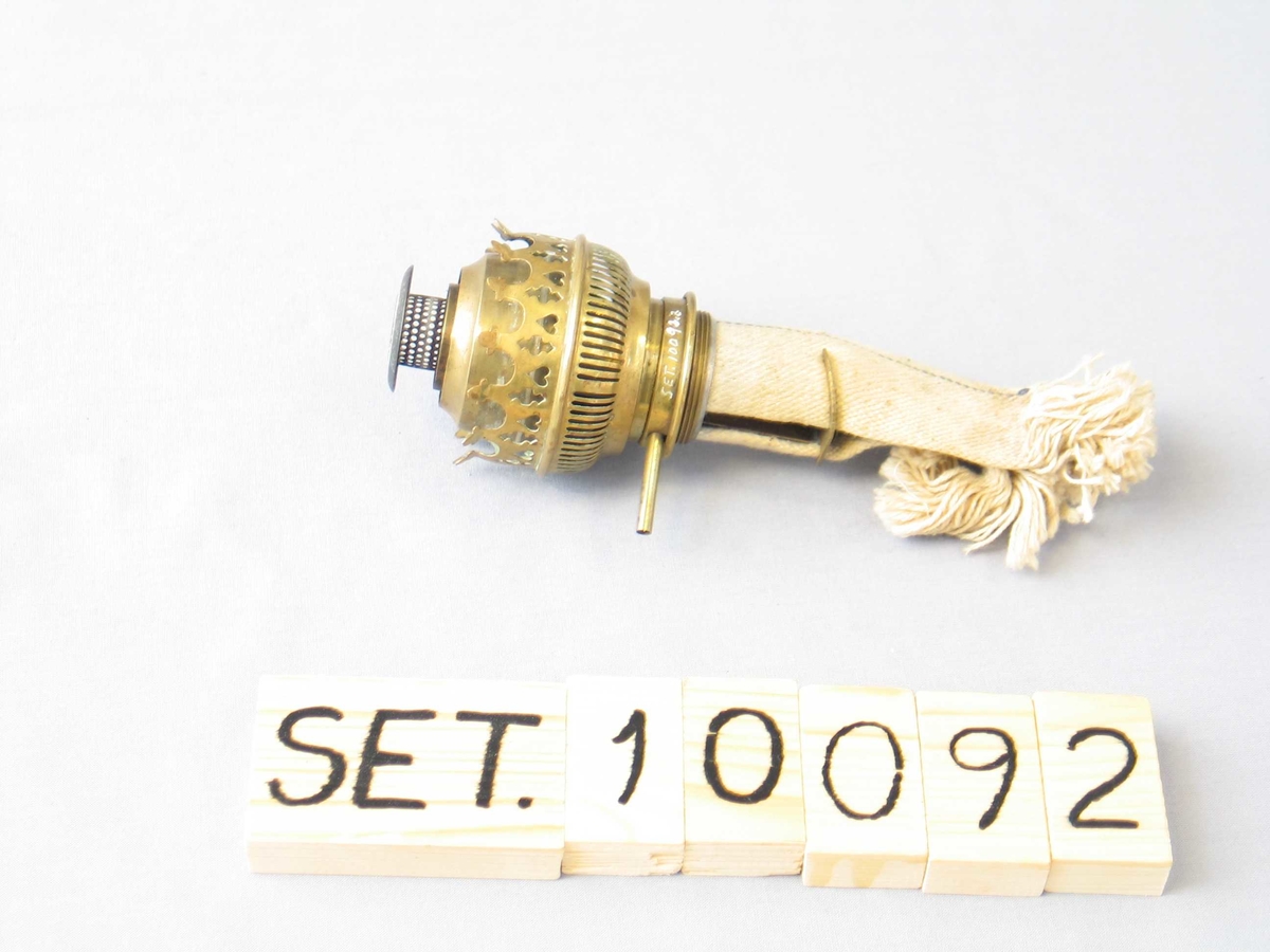 Parafinbrennar av messing, med veik. Skruve til å trekkje fram veika manglar.