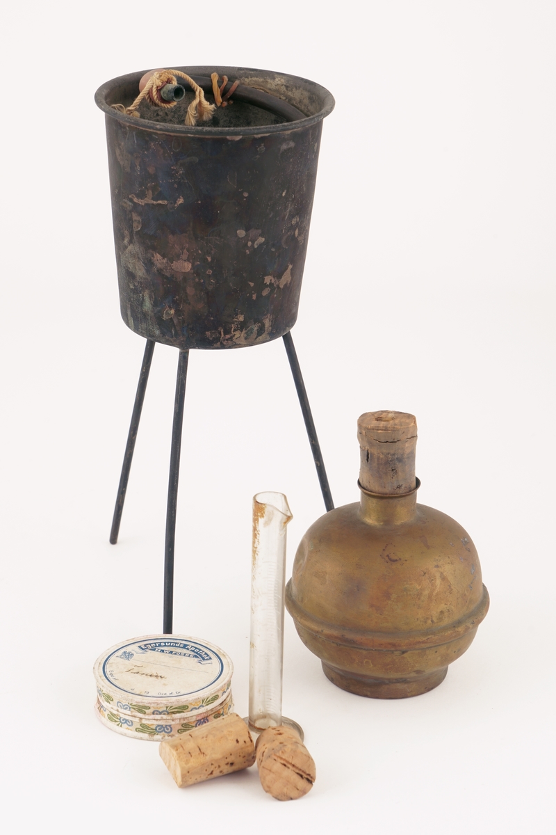 Følgende utstyr er pakket i en tre eske med lokk:
- et målerør i glass
 -to korker
-Metallkopp på tre føtter isatt spiralrør med utløp i bunnen.
-Beholder av metall med gjennomhullet kork
-Rund pappeske med lokk med innhold av formentlig taniner