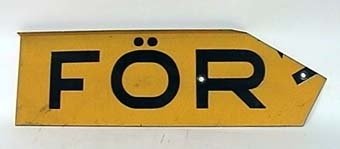 Skylt av gul reflekterande plåt med svart text:
"VARNING FÖR TÅG".
Skylten består av fyra plåtar med text och en hållare för montage i kryss.
Den gula färgen har glaspärlor som ljusreflekterande materiel.
"Krysset" har ingjutet ÖR 9183 på baksidan.
Ihopmonterat har krysset måttet bxh 560x340 mm.
Plåtarna är gråmålade på baksidan.