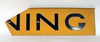 Skylt av gul reflekterande plåt med svart text:
"VARNING FÖR TÅG".
Skylten består av fyra plåtar med text och en hållare för montage i kryss.
Den gula färgen har glaspärlor som ljusreflekterande materiel.
"Krysset" har ingjutet ÖR 9183 på baksidan.
Ihopmonterat har krysset måttet bxh 560x340 mm.
Plåtarna är gråmålade på baksidan.