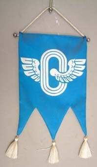 Bordsstandar med blå treflikig flagga. I mitten tryck av en vit bevingad oval. Vita tofsar nertill. Sockel av grå marmor med en silverplatta med följande text på finska:
"Tennis
Ruotsi-Suomi
Örebro  7.6.1980
VR Urheilu".

Ungefärlig översättning: "Tennis Sverige-Finland Örebro 7.6.1980 VR idrott".