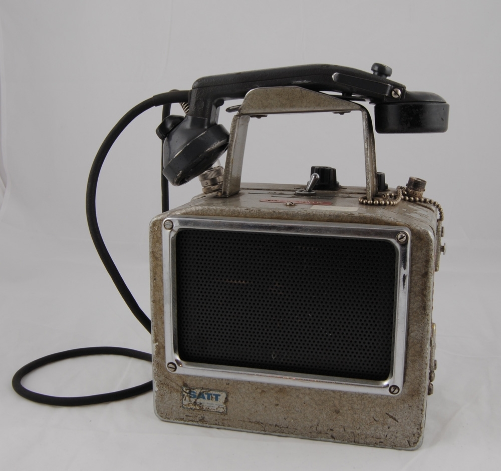 Växlingsradio Autophon SE 18 HAZ, bärbar. Bärhandtaget är utformat för att hålla uppe luren. Högtalare på framsida. Klisteretikett "SATT Svenska Aktiebolaget Trådlös Telegrafi Stockholm 32 Sweden". Med röd dymoremsa "HALL-LOK". Märkt "VOLYM", "HÖG" och "LÅG". Frekvens: 160-170 MHz. Mikrofon: MT 18. Ackumulator: AK 18. Högtalarförstärkare: SJ Spec. Märkt på höger och vänster sida "Återlämnas till TKM Hall Lok". Metallbricka: "Sender-Empfänger SE 18 H A Z2 Fabr.Nr. 8779 Autophon AG. Solothurn".

Modell/Fabrikat/typ: Autophon SE 18 HAZ