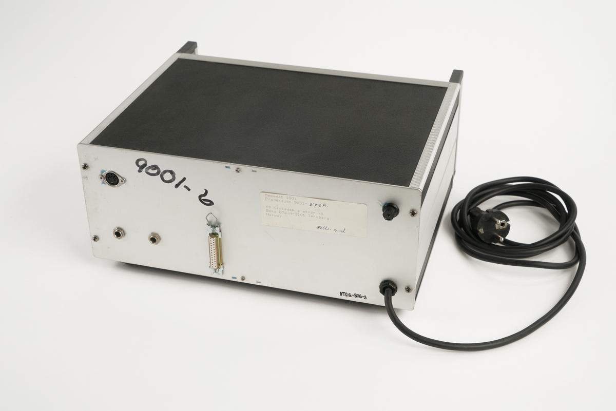 Telefonapparat med taster nummerert fra 0 til 9 og med firkant- og stjernetast. Telefonrør  er tilkoblet med spiralisert ledning. Apparatet er utstyrt med 6 knapper for forhåndsinnstilling av telefonnummer. Videre er det knapper for minne, hold- og høyttalerfunksjon. Volumbryteren er et rullehjul. Fra undersiden kan man dra ut et plastkort/telefonliste. 

I tillegg medfølger to  instrumentbokser med mulighet for å  ta opp og lagre samtaler. I front på den ene er det et vindu med antatt digital tekst og diverse  "softtouch" knapper til å bearbeide opptak. To brytere for antatt å kunne justere lydstyrken. Videre er det montert ulike  utganger for tilkobling av diverse utstyr bl.a. headset. Det er også montert en diskettstasjon med åpning i front. På baksiden av opptakeren er det montert ulike dataporter og strømtilkoblinger. Jordingskabel med skjøtekobling. Strømkabel medfølger.

Den andre boksen er forsynt med to håndtak i front, samt en luke/deksel på venstre side, med gjennomsiktig vindu av plast,  som kan åpnes for isetting av kasettbånd. På høyre side i fronten er det et gjennomsiktig rødt plastvindu hvor det er gjort hull slik at man kommer til en hvit trykkbryter. Fronten er videre påsatt en blå, vridbar bryter, en hvit vippebryter med rød og grønn lampe, samt fire sorte trykkbrytere med hvit tekst: "START" "STOP" og høyre/venstre pil. Nederst er det en sort trykkbryter som formentlig benyttes til å åpne dekslet til kasettbåndet.Til høyre for denne bryteren er det et kontaktpunkt for tilkobling av tilleggsutstyr.
På baksiden av boksen er det fire ulike kontaktpunkter for tilkobling av tilleggsutstyr samt fastmontert strømkabel med kontakt. Videre er det montert en skrubar sikringsholder.
Under boksen er det montert fire, høydejusterbare, ben