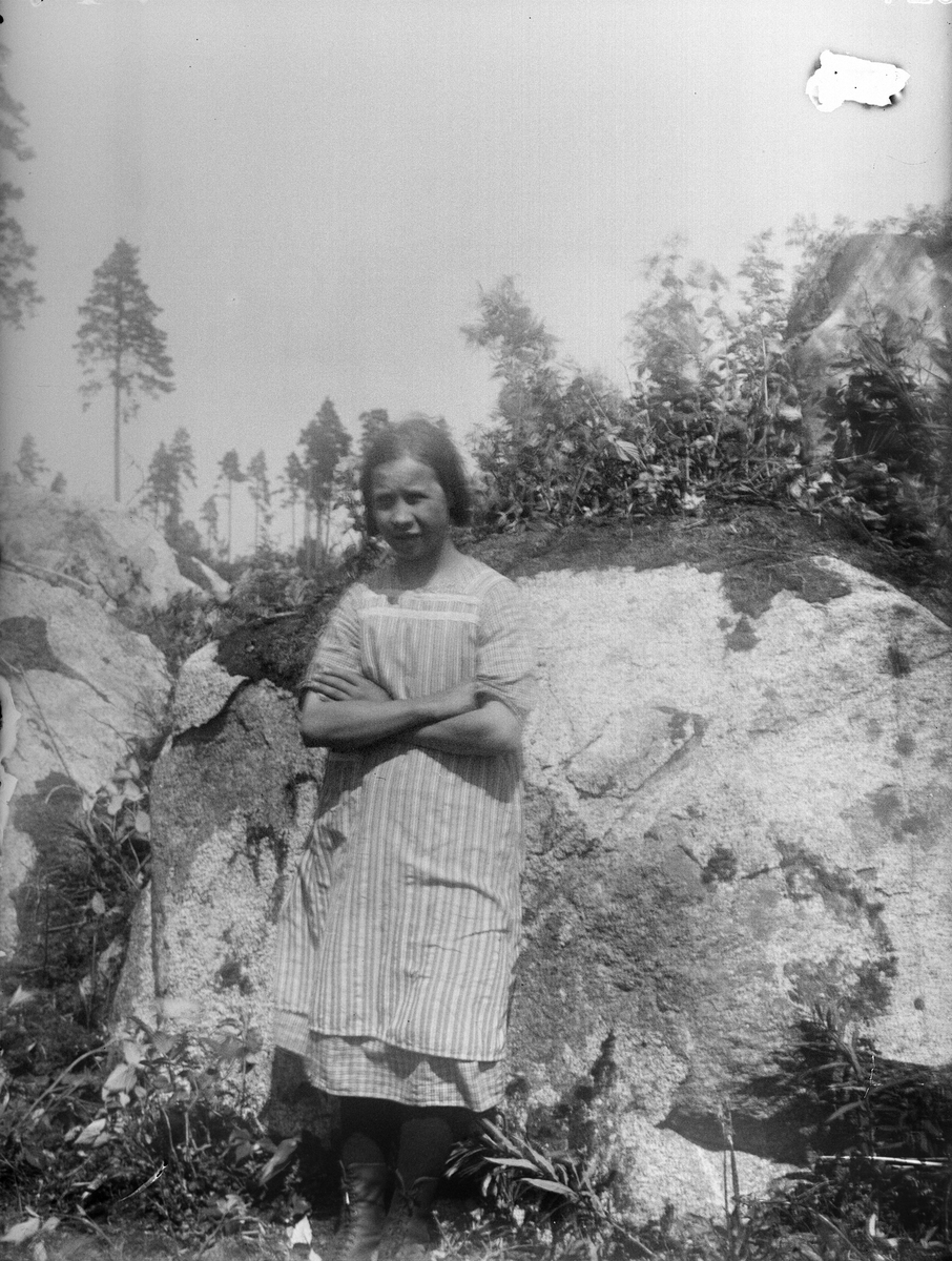"Ensam flicka ur planteringslaget, vid stenen med armarna i kors", Kattmossen, Altuna socken, Uppland 1924