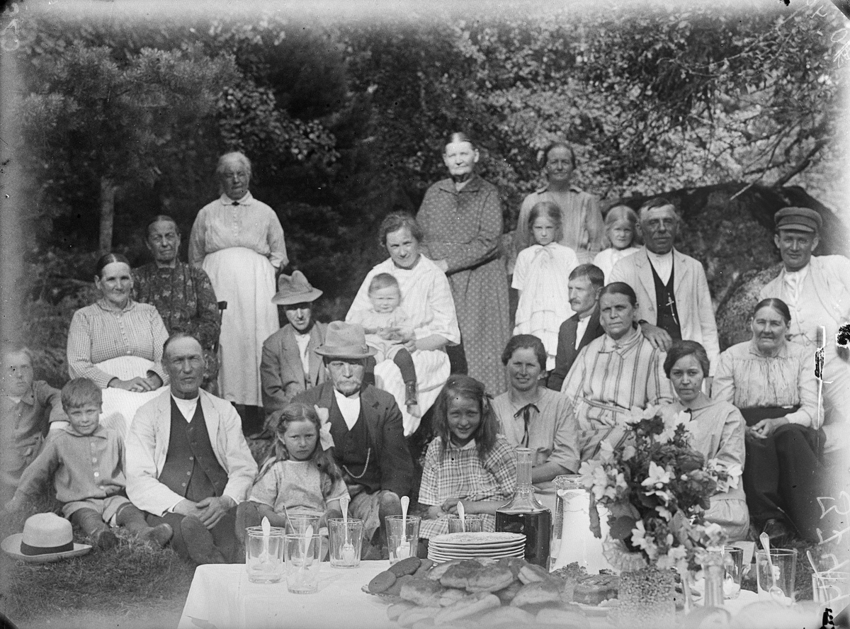 Grupporträtt vid dukat bord i skogskanten med bland annat Karolina och August Alinder, Uppland 1925