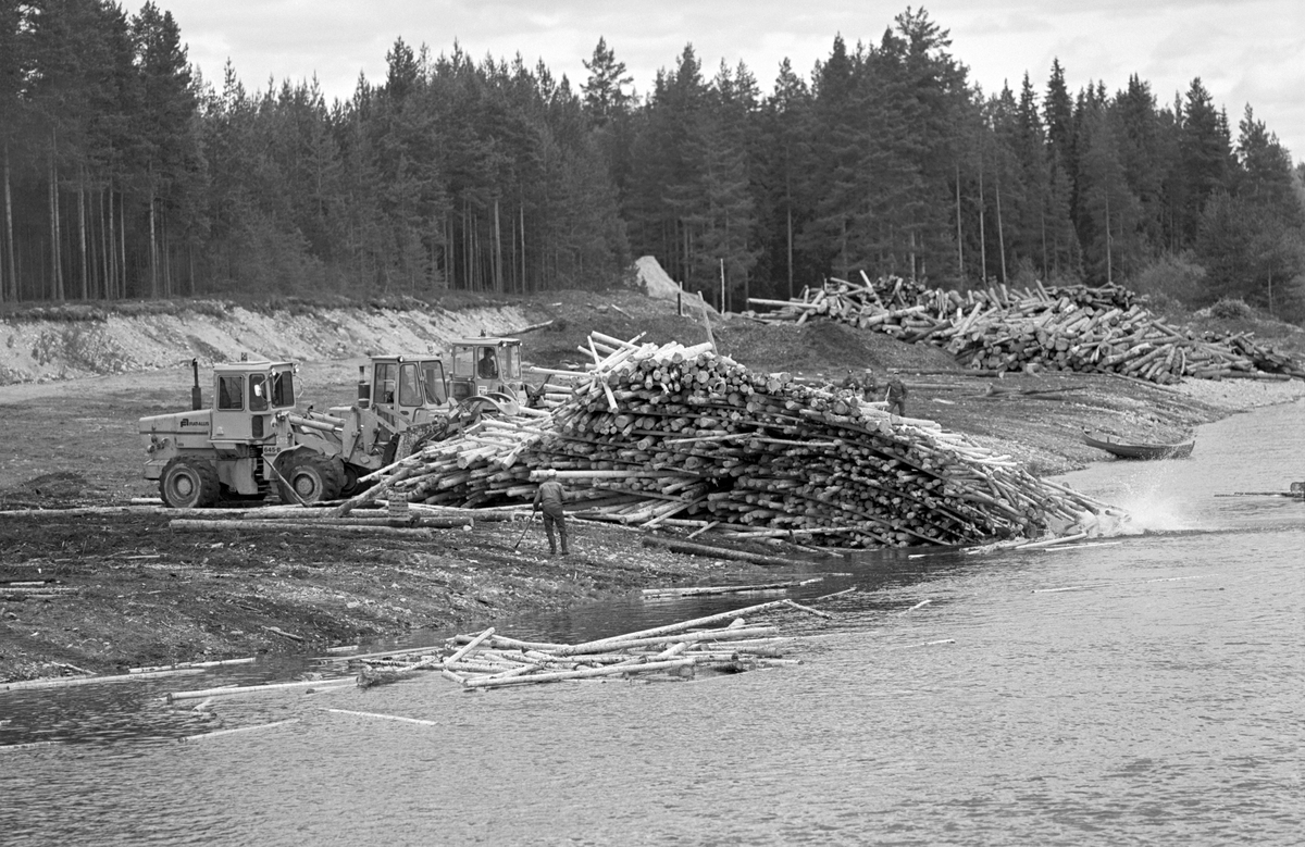 Maskinelt utislag av fløtingstømmer i Glommavassdraget tidlig i 1980-åra (sannsynligvis i 1981), fra Storvelta i Flisa-elva. Bildet er tatt lengst nord på Storvelta under Haneknefossen.  Her utførte Glomma fellesfløtingsforening tidlig i 1950-åra en del «elverensingsarbeid» med bulldoser. Maskinen skjøv stein fra den sentrale delen av elvefaret ut mot kantene, slik at vassdraget fikk et mer avgrenset løp uten store steinblokker som kunne skape hindringer for fløterne. Den ble også brukt til å planere elvebakken, slik at den fikk en jevn, svaktskrånende overflate hvor det kunne legges opp tømmer i forkant av kommende fløtingssesonger. Denne plassen skulle ha en kapasitet på opptil 10 000 kubikkmeter tømmer.  Her ser vi tre anleggsmaskiner som skyver florlagt tømmer ned den skrå flata mot elva, hvor de ytterste stokkene møter vannflata omgitt av kvitskummende vannsprut.  En fløter med hake i hendene følger maskinenes arbeid fra en posisjon på den svaktskrånende velteplassen.  I bakgrunnen sto det forholdsvis høy, tett barskog. 

Det ble gjort utbedringer av Storvelta på 1970-tallet slik at, hjullastere (griplastere) og maskineri for barking skulle få bedre plass. Storvelta er om lag 400-500 lang og ligger på vestsida av Flisa-elva. Velteplassen ble kjøpt av Marius Bredvold, som eide tilstøtende arealer, etter at fløtinga i dette vassdraget var avviklet.