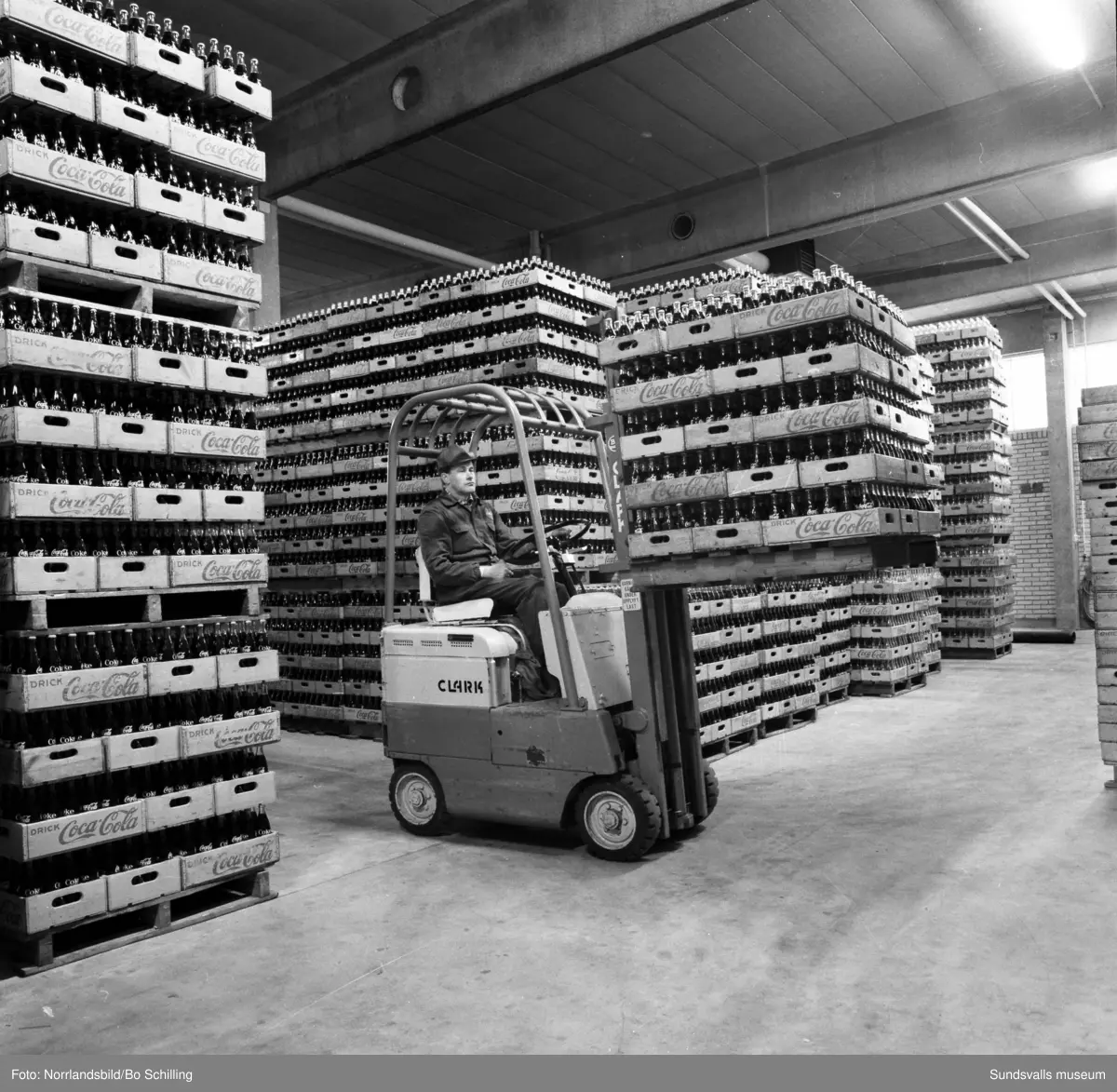 Coca-Cola-fabriken vid Bultgatan i Nacksta. Exteriörbilder samt bilder från lagret, en man kör truck bland tomma och fyllda flaskor.