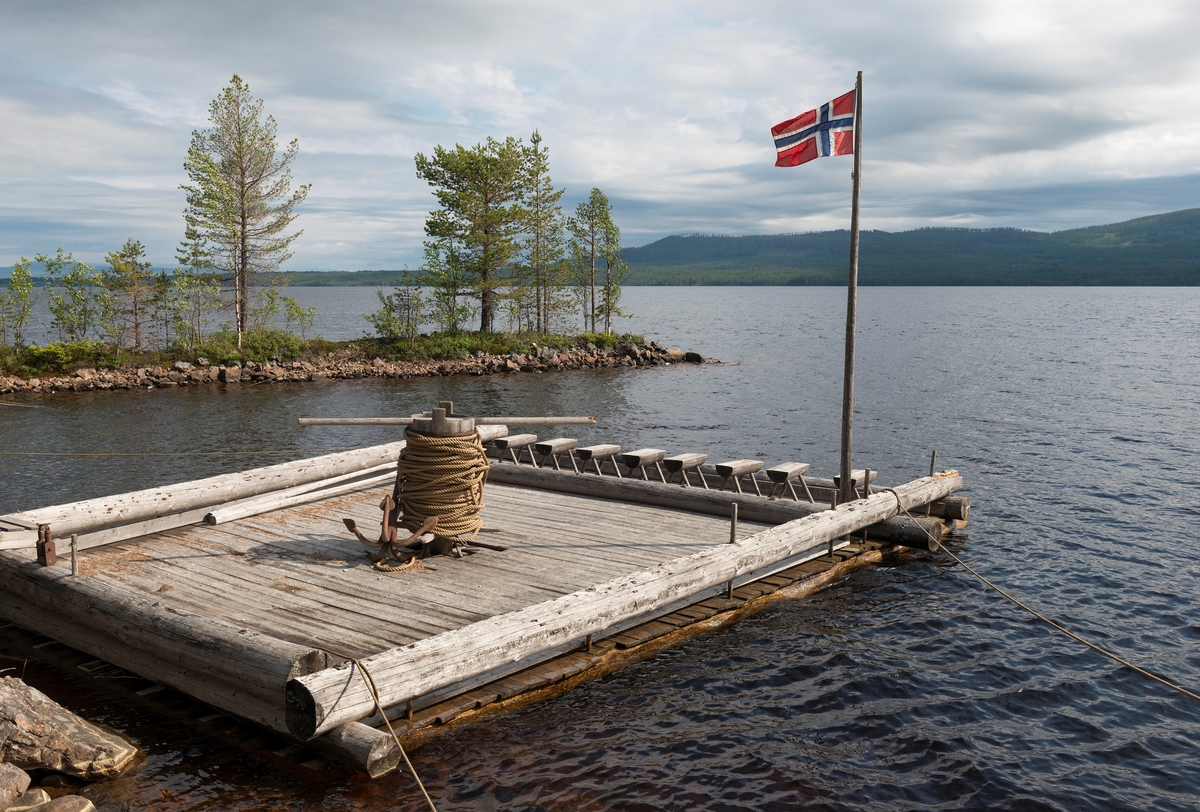 Spillflåte ved Sørlistøa fløtermuseum i Åmot kommune i Hedmark.  Dette er altså en tømmerflåte med et gangspill på.  På gangspillet var det ei lang trosse med en «dregg» (et anker) i enden.  Ankeret ble rodd framover i sjøen og sluppet ned på botnen, der det festnet seg.  Deretter kunne fløterne begynne sin gang rundt «tønna», vindespillet, slik at flåten og en bakenforhengende tømmerbom gradvis beveget seg om ankringspunktene, som gradvis ble flyttet nærmere Valmen og elva Søndre Osas utløp fra Osensjøen.  Øivind Vestheim, som var amanuensis ved Norsk Skogbruksmuseum, har beskrevet flåtetypen slik: 

«Flåten ble lagd av det fineste virket av fløtningstømmeret.  Det skulle være 23 stokker for å få riktig bredde.  Flåten ble satt sammen på land, og den var neste kvadratisk.  Det var nødvendig for å få god gangplass når to mann skulle gå i bredda og skru tynna rundt ved hjelp av to lange stenger, «årer». 

Helst brukes det gran til å bygge flåte av fordi den var tørrest.  Men om det fantes fine furustokker, kunne også det brukes.  Det ble hogd store hull i toppenden på hver stokk og drevet etter en bjelke, som skulle bidra til å holde flåten sammen foran.  Så ble det lagt en stokk tversover, boret hull gjennom det heile og slått inn trenagler.  Flåten var litt smalere foran, fordi alle stokkene lå med toppen fram. 
Tømmeret skulle være 12 alen eller omkring 15 halvmeter langt.  Det ble ikke brukt dobbelt lag.  Men når en skulle ha all «pargasen» utpå flåten, ble det stukket særlig lett tømmer under for å få bedre oppdrift og flyteevne.  Understokkene ble så gjølt fast til flåten ved hjelp av spesiell kjetting, som ble kalt flåtaband.  Det ble brukt 20-22 understokker, som de la langsetter hver fuge mellom flåtestokkene.  Også understokkene lå med toppendene framover.  Oppå flåten ble det lagt vrakbord på tvers for å få et jamt golv å gå på. 
Det var lagt en stokk på ytterkanten langsetter på hver side av flåten, for det måtte være feste til årer.  Flåten ble nemlig rodd når den var tom, og når en skulle over sjøen for å hente ny bom.  Hele mannskapet på 8 rodde med hver si åre (4 årepar), som var mye lengre og kraftigere enn vanlige årer til robåt. » (Fra artikkelen «Med tømmer over Osensjøen» i Norsk Skogbruksmusums årbok nr. 11 (1985-1986)

Den omfattende bruken av slike spillflåter på Osensjøen opphørte da slepebåten «Trysilknut» ble satt i drift i 1914.  Spillflåter var likevel noe i bruk i forbindelse med landrensk også i åre som fulgte, og på de mindre Ulvsjøene lengre øst var denne måten å få fram tømmeret på i bruk til slutten av 1960-åra.  Spillflåten på fotografiet er en kopi som er lagd ved Sørlistøa fløtermuseum i nyere tid etter ovenstående beskrivelse, antakelig lagd i 1991.  De mange små krakkene med seter av halvkløvninger er vel helst plassert på flåten med tanke på unger som bruker den som plattform for fiskeaktiviteter. 