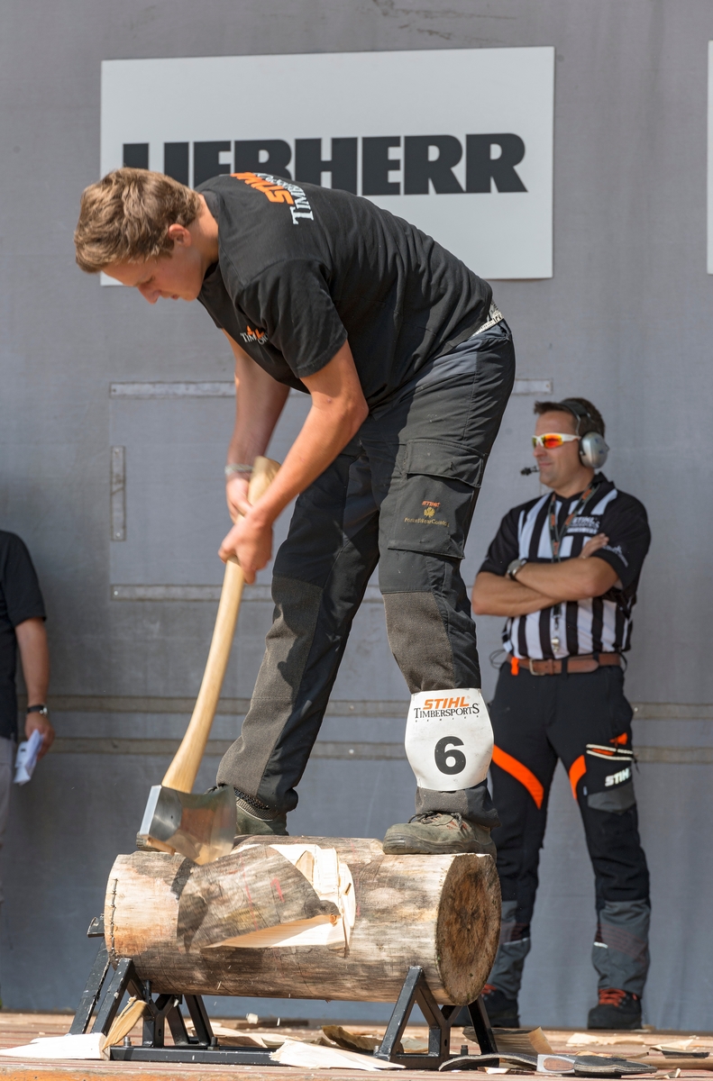 Fra nordisk mesterskap i «Stihl timbersports» under De nordiske jakt- og fiskedager på Norsk Skogmuseum i Elverum torsdag 7. august 2014.  Her arrangerte skogsredskapsprodusenten Stihl konkurranser, der deltakernes hurtighet og presisjon i arbeid med øks, stokksag og motorsag ble bedømt og premiert.  2014 var det første året denne konkurransen var lagt til Norsk Skogmuseum og De nordiske jakt- og fiskedager.  Da dette fotografiet ble tatt var en av deltakerne i ferd med å dele en kabbe som han sjøl sto på ved hjelp av øks, en øvelse der tidsfaktoren var viktig i forhold til konkurrenter som kappet andre kabber med samme dimensjon med samme redskap.  En jury fra arrangørenes stab kåret for øvrig aktivitetene på Stihls scene til «Årets event» med følgende begrunnelse: «Formidler kunnskap om tradisjonelle teknikker i en moderne og underholdende form.  Stor publikumsappell med spektakulært show. »

«Stihl timbersports» er en internasjonal konkurranse for tømmerhoggere. Den har sitt utspring i Canada, USA og New Zeeland, der skogsarbeidere alt på 1800-tallet skal ha arrangert lokale konkurranser for å kåre den beste blant dem. Med tida ble det utviklet tester for vurdering av styrke og ferdighet i konkurranser på høyt nivå med profesjonelle aktører. I 1985 stiftet STIHL Inc. USA, i samarbeid med sportskanalen ESPN, det som ble «Stihl timbersports series», som er en konkurranseserie i USA og Europa.  2014 var det første året slike konkurranser ble avviklet i Norge. Konkurransene består av seks grener: tre med øks, to med motorsag og en med svans. Øvelsene simulerer felling av stående trær og kapping av felte trestammer. Utøverne får testet arbeidsteknikk, styrke og utholdenhet.