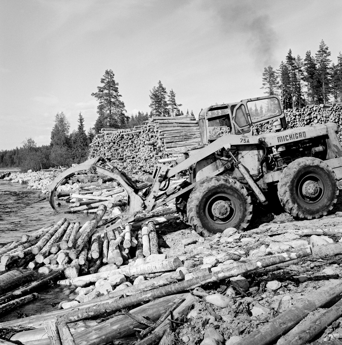 Utislag av maskinbarket slipvirke (cellulosetømmer) ved hjelp av anleggsmaskin med gripeklo fra en velteplass ved en elvebredd langs elva Flisa, ei elv som renner gjennom Våler og Åsnes kommuner i Hedmark.  Fotografiet er tatt idet maskinføreren slapp en del tømmer han hadde hentet fra en bakenforliggende velteplass i vannet ved elvebredden.  Dette var tømmer som var hentet langs skogsbilveger i omkringliggende skoger med tømmerbiler og samlet på dette stedet for maskinelt utislag, muligens også maskinell barking.

I 1960-åra ble det bygd terminalplasser med barkemaskiner ved flere av de store fløtingselvene i Norge.  På disse plassene samlet man tømmer som var framkjørt ved hjelp av tømmerbiler på de mange skogbilvegene som var bygd i etterkrigsåra.  På denne måten kunne en unngå den mannskaps- og kostnadskrevende fløtinga på de minste vassdragene.   I 1966 ble det dessuten inngått en avtale mellom Glommen Cellulosetømmerkjøperes forening, skogeierforeningene for regionene som soknet til Glomma- og Mjøsvassdragene og Glomma fellesfløtingsforening om at det skulle installeres barkemaskiner på flere terminalplasser.  Teknisk konsulent Carl Fredrik Lindeman i Glommen skogeierforening mente at det burde etableres slike plasser med maksimum 25 kilometers innbyrdes avstand oppover langs Glomma.  Det ble etter hvert 42 terminalplasser med barkeanlegg.  De sparte skogsarbeiderne for den manuelle barkinga, som i streng vinterkulde kostet dem mye tid og krefter.  For skogeierne innebar bruken av terminalplasser for tømmer at de slapp floring og utislag.  Terminalplassene muliggjorde dermed rasjonalisering av så vel skogsarbeid som tømmertransport. Fløting av tømmer. Skogbruk.