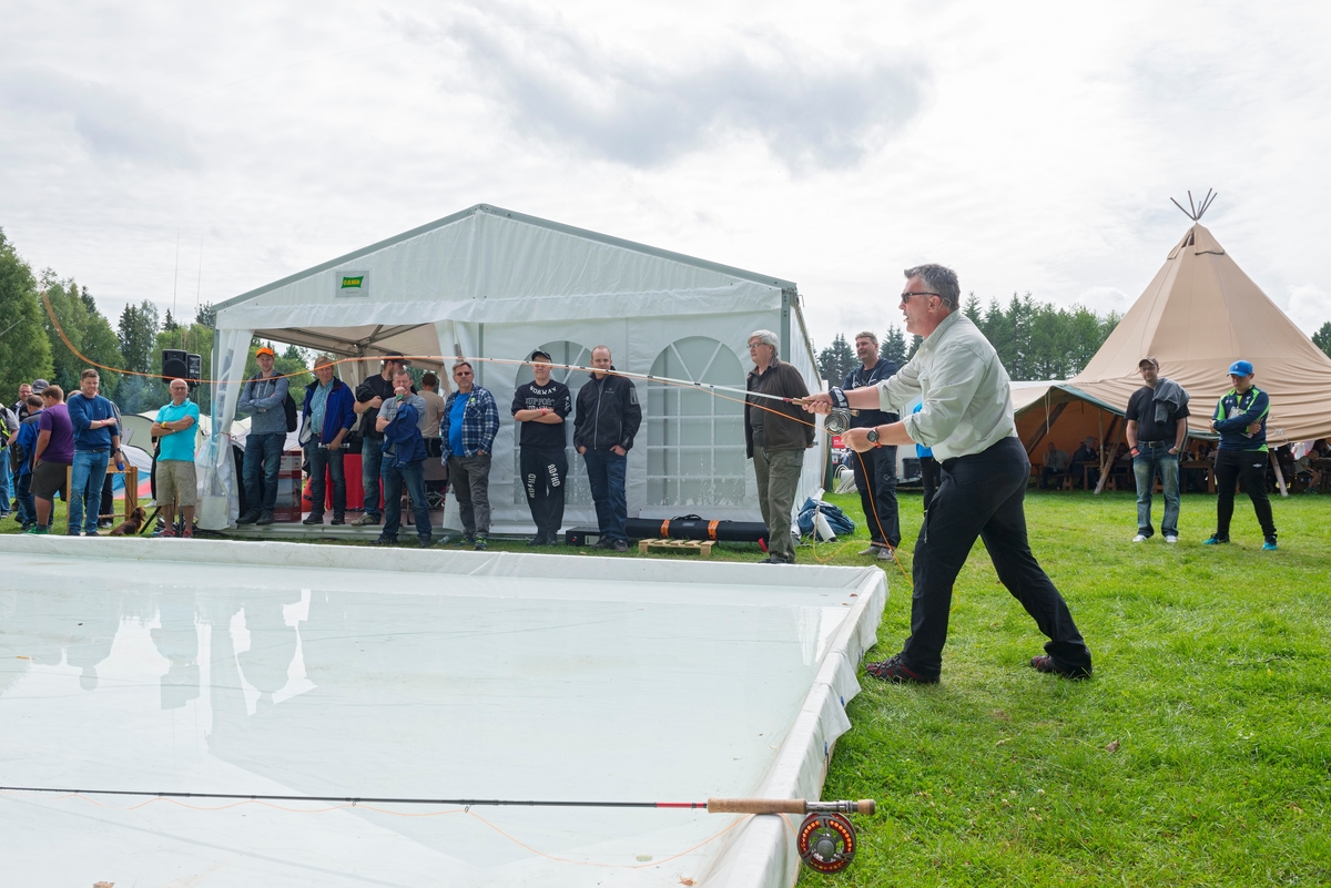 Skotske Hywell Morgan demonstrerer kasteteknikk med fluestang.  Fotografiet er tatt under De nordiske jakt- og fiskedager på Norsk Skogmuseum i Elverum i 2015.  Selskapet Villmarksbutikken på Jessheim hadde satt opp et langt, rektangulært kastebassen av kvit plast ved sin stand, der Morgan og flere andre dyktige fluefiskere viste kasteteknikk.  Dette var et inspirerende innslag for fluefiskerne som besøkte arrangementet , og et viktig blikkfang for Villmarksbutikkens stand.