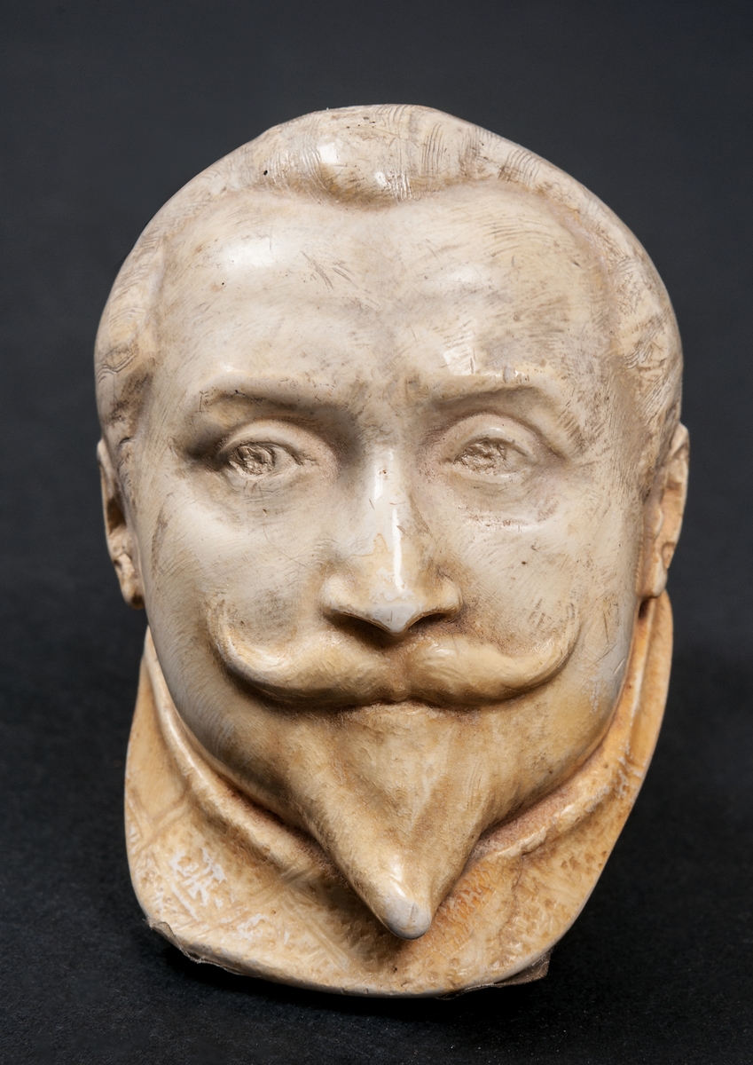 Rökpipa, snidad i sjöskum, skaft av trä med förlängning. Piphuvudet format som Gustaf II Adolfs huvud, gjort av Ida Matton, Gävle.
Texter i låg relief på sidorna:
*1594 † 1632. GUSTAF II ADOLF.
1613 Knäröd. 1617 Stolbova. 1631 Breitenfeld. 1632 Lützen.
Ida Matton Anno 1893.