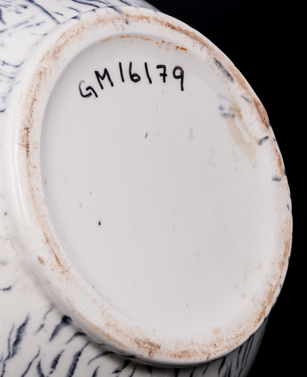 Tvättservis av vitt porslin med marmorering i grått. Servisen består av handfat, potta, en avlång tvålkopp och en kvadratisk, båda med lock. Handfatet stämplat Gustafsberg.