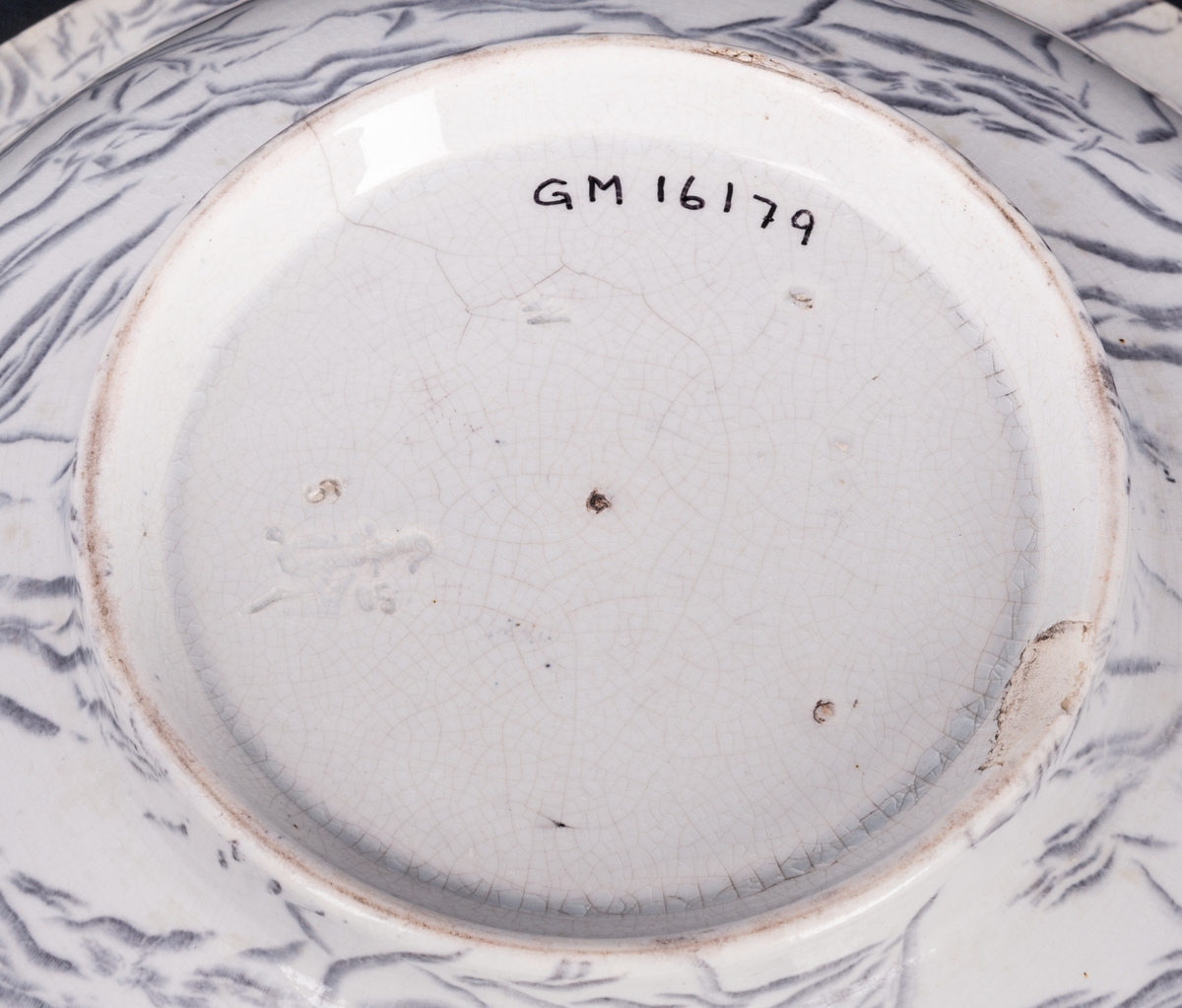 Tvättservis av vitt porslin med marmorering i grått. Servisen består av handfat, potta, en avlång tvålkopp och en kvadratisk, båda med lock. Handfatet stämplat Gustafsberg.