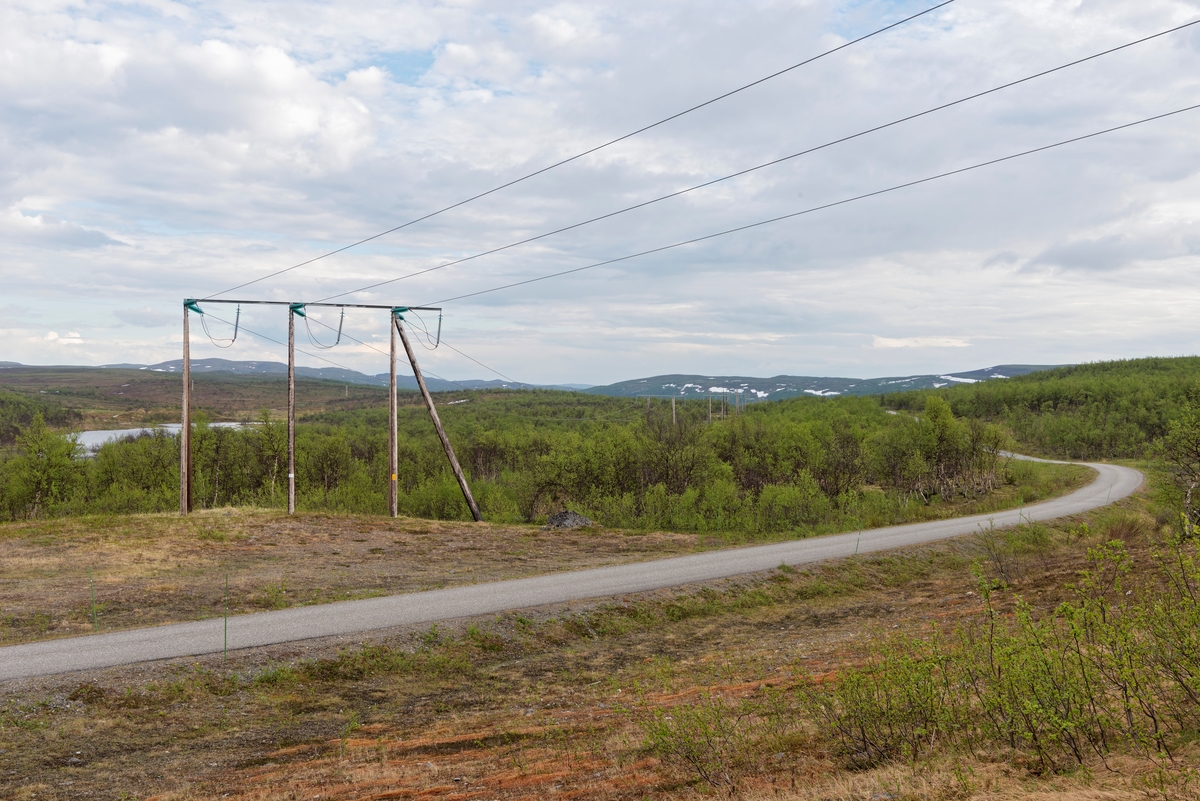 Anleggsveien mellom Stilla og Altadammen innenfor bommen ved Tutteberget. Alta, Finnmark. Veg i fjellandskap. Master for overføring av kraft. Kraftmaster.