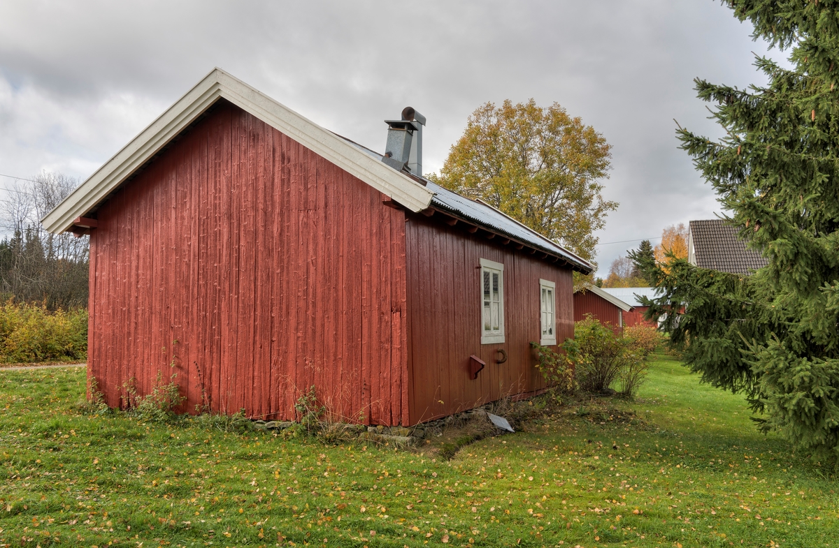 Smie- og verkstedbygningen til knivmakeren Even Johannes Blindingsvolden (1908-1985) på småbruket Rudsland på Rudshøgda i Ringsaker, sett fra øst.  Bygningen er oppført i bordkledd bindingsverk, delvis på en lav tørrmurt gråsteinsmur, dels på en støpt mur.  Grunnflata er på cirka 43 kvadratmeter.   I den sørøstre enden (nærmest fotografen), er det et smierom på cirka 18 kvadratmeter.  Den vesle «hylla» på ytterveggen dekker inntaksrøret til vifta som ble brukt til å blåse oksygenrik luft inn i glødende smiekol når det var berhov for å øke temperaturen i avlen (essa).  I den nordvestre delen av bygningen hadde knivmakeren verkstedet sitt  Her er veggene og himlinga isolert med sikte på helårsbruk, og det er vinduer i ytterveggene, som supplert med elektriske lamper gav godt arbeidslys.  Bygningen hadde dører mot Prestvegen, som går langs den sørvesgtre langveggen (til venstre på dette fotografiet).  Taket var opprinnelig flistekket, som det seinere ble lagt bølgeblikk oppå.  Røyken fra vedovnen i verkstedrommet og avlen i smia ble ført opp over taket via røykløp av sveisestål.  Til høyre i bakgrunnen ser vi noe av den øvrige bebyggelsen på eiendommen Rudsland.

Mer informasjon om verksted- og smiebygningen, samt om knivmakeren Even J. Blindingsvolden, finnes under fanen «Opplysninger».