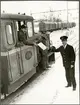 Stationsmästare Gunnar Fredriksson vid Hälleforsnäs station tar emot frakthandlingar från AB Järnförädling. På lokomotorns fotsteg står Gunnar Engvall. Trafikaktiebolaget GrängesbergOxelösunds Järnvägar, TGOJ Z4 9.