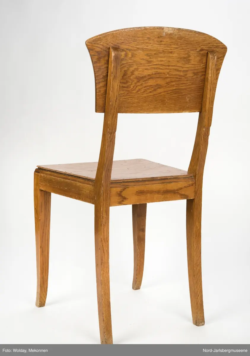 Enkel stol i lakkert finer, uten armledner. Ryggstøplaten med en fint buet overkant.