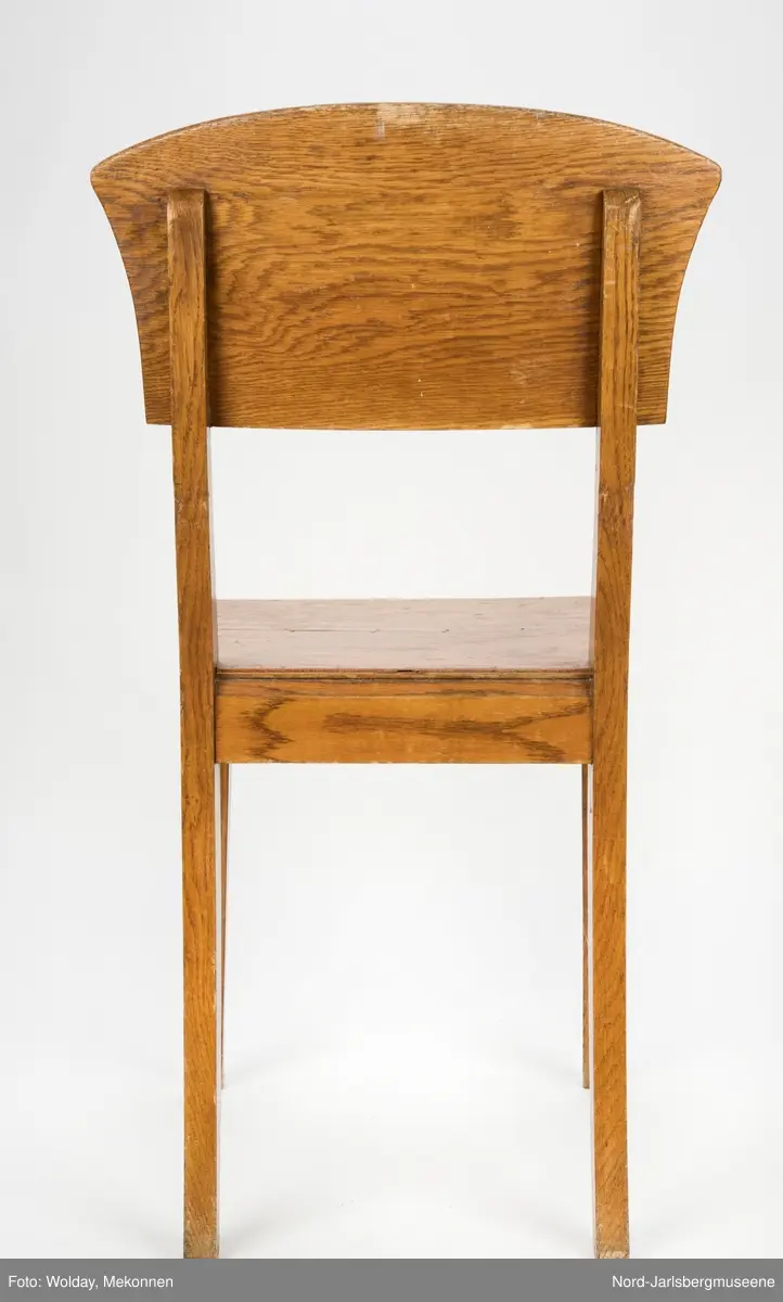 Enkel stol i lakkert finer, uten armledner. Ryggstøplaten med en fint buet overkant.