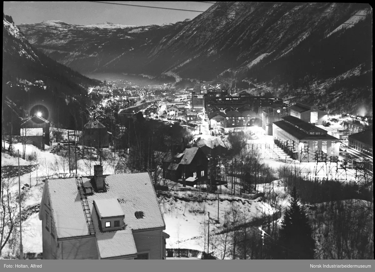 Øvre bydel med Hydroparken til høyre, og Såheim kraftstasjon bak.
Fotografert om natten, slik at gatebelysningen og lyset fra fabrikkområdet fremheves.