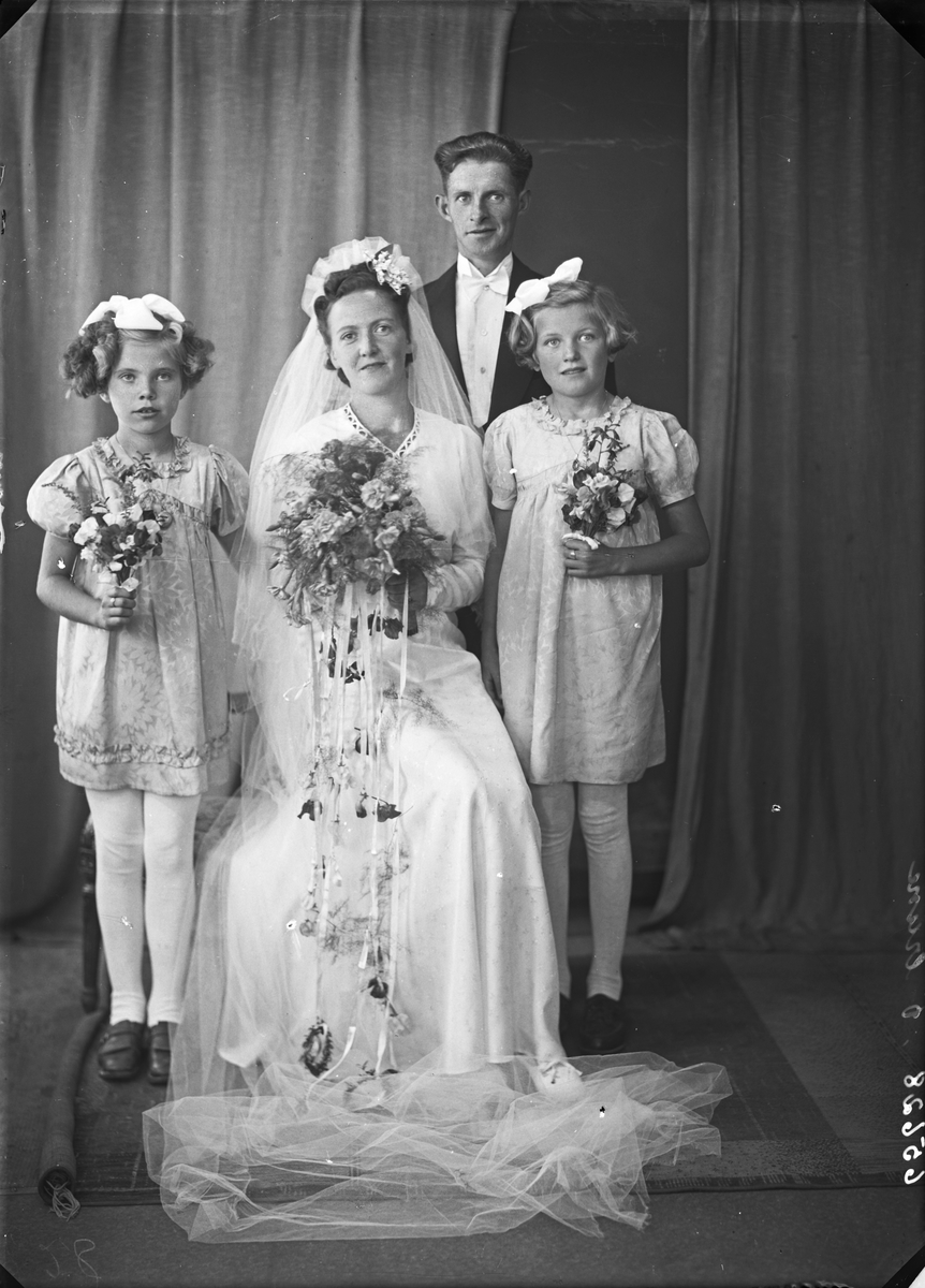 Gruppebilde. Brudegruppe. Ung kvinne, ung mann og to brudepiker. Brudgommen kun med på et foto. Bestilt av Hr. Thoralf Torgrimsen. Ølen
