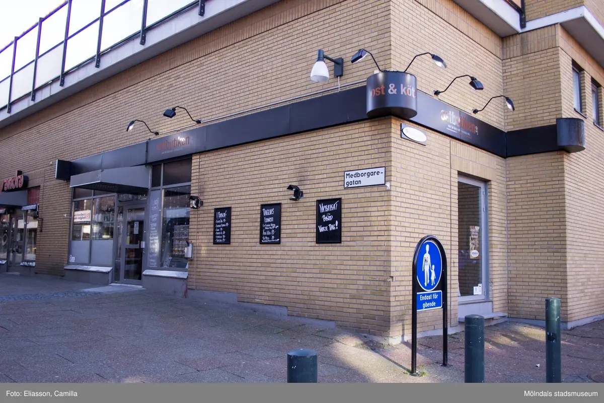 Medborgaregatan sedd från Bergmansgatan, år 2015. Bild 1-3: på höger sida ses fastigheten Hajen 2 (Ostbutiken, Boutique Sandra, Royal Indian Kitchen samt Fiskhallen). Bild 4-5: på vänster sida ses fastigheten Havskatten 12 (Smycka Leif Carlson, Isak & Berg samt Klädboden). Dokumentation av platsen innan rivning och nybyggnation.